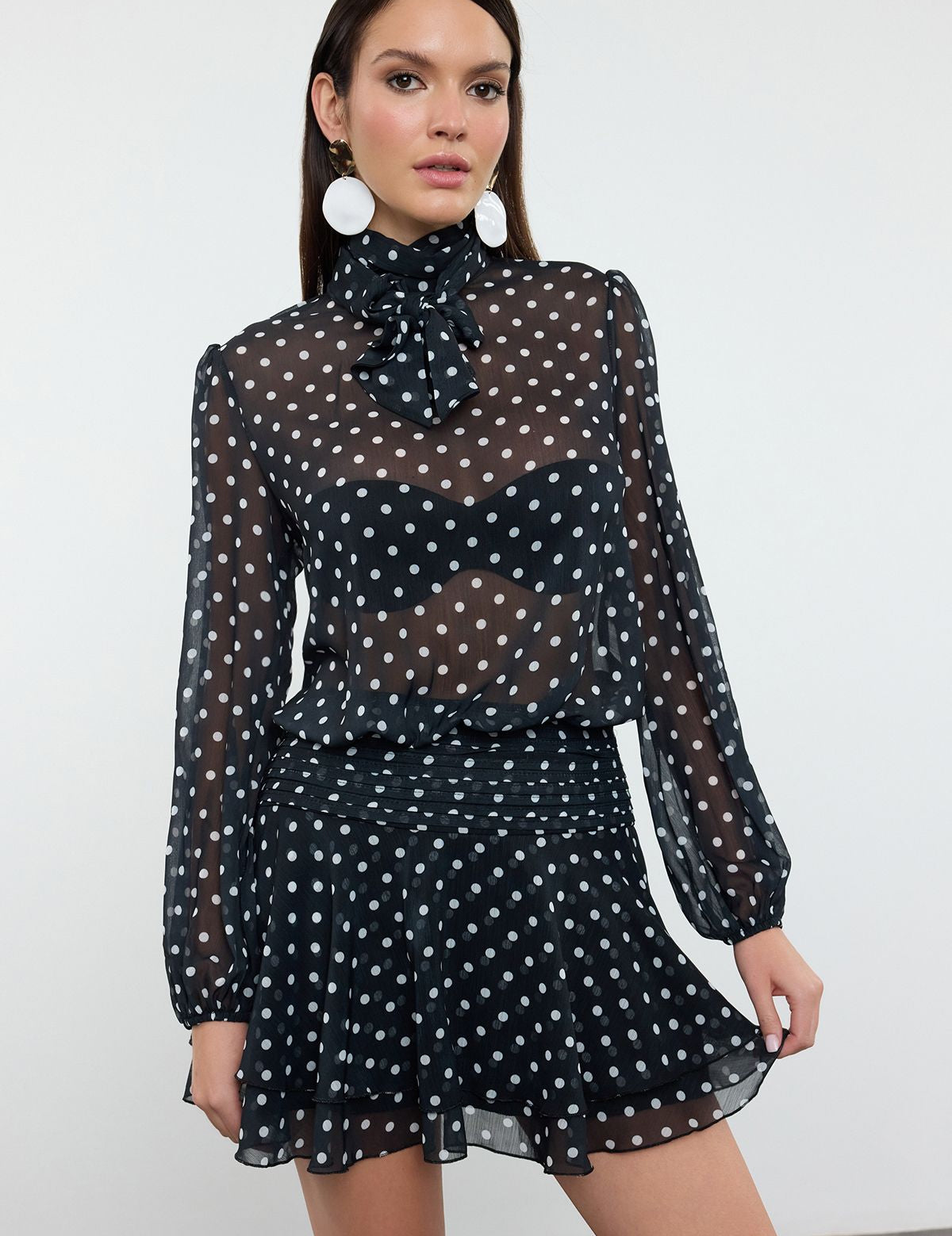 Chic Sheer Polka Dot Blouse and Ruffled Skirt Set – Elegant Black and White Outfit

Make a stylish statement with this black and white polka dot set. Featuring a sheer blouse with bow-tie neck and a high-waisted ruffled skirt, this outfit is perfect for evening events or special occasions.
