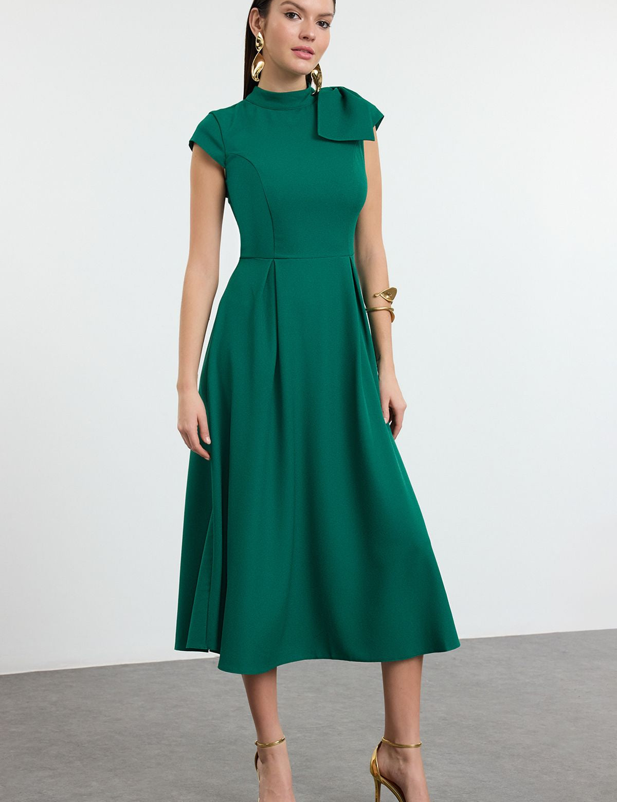 Shop this elegant green midi dress with bow detail and cap sleeves. Perfect for formal events, weddings, or cocktail parties, this fit-and-flare dress is timeless and chic.