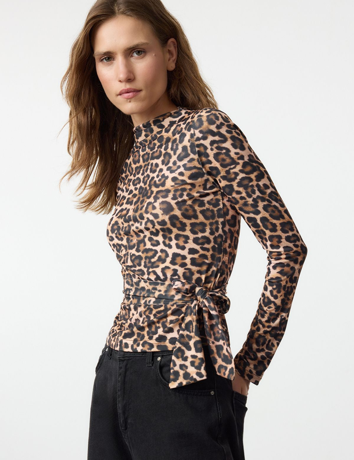 Turn heads with our leopard print long-sleeve wrap top. Featuring a tie detail at the waist, this chic blouse is perfect for day-to-night styling. Shop now!