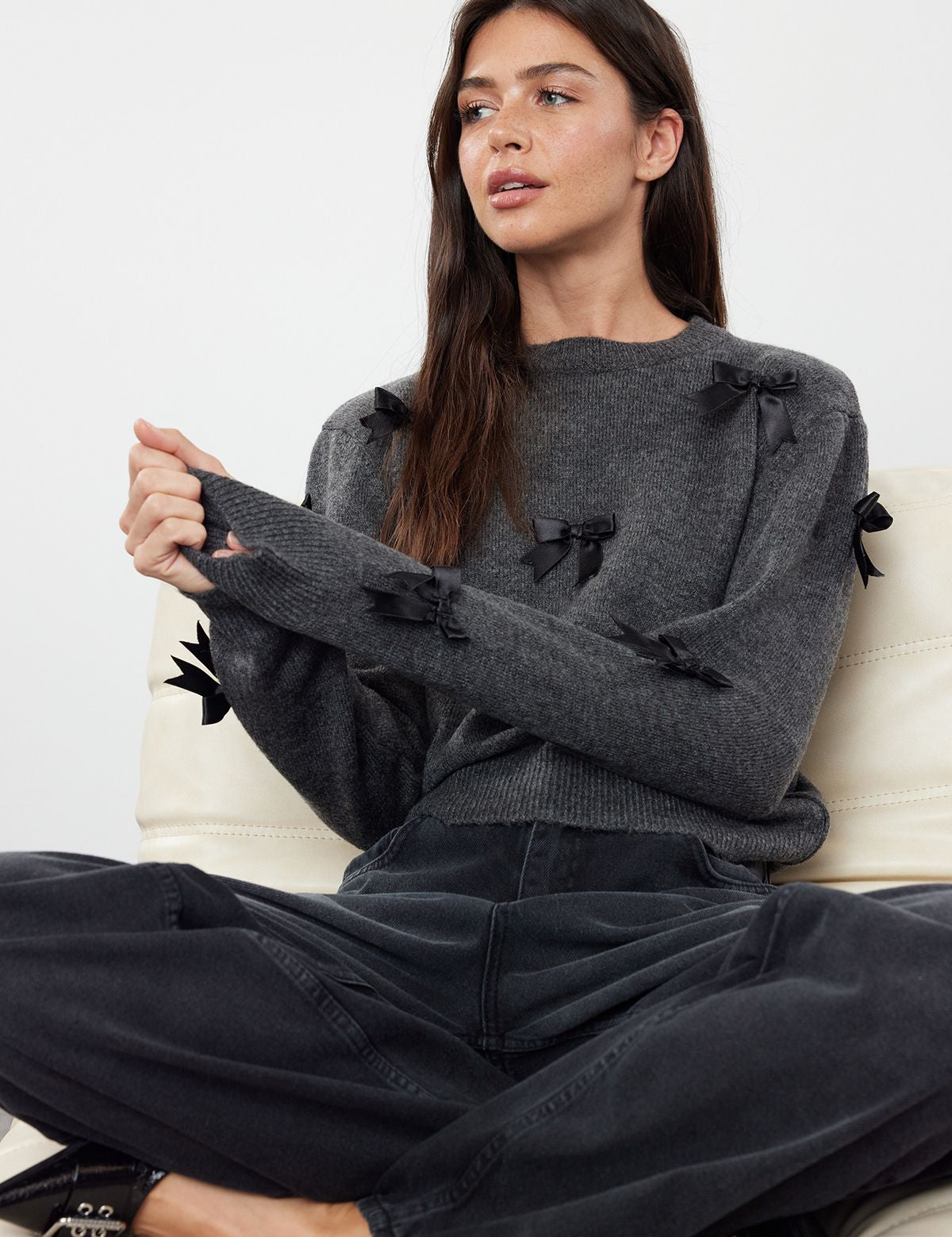 Discover a touch of elegance with our charcoal sweater adorned with chic black bows. Perfect for any casual or semi-formal occasion, this cozy sweater brings feminine charm to your wardrobe.