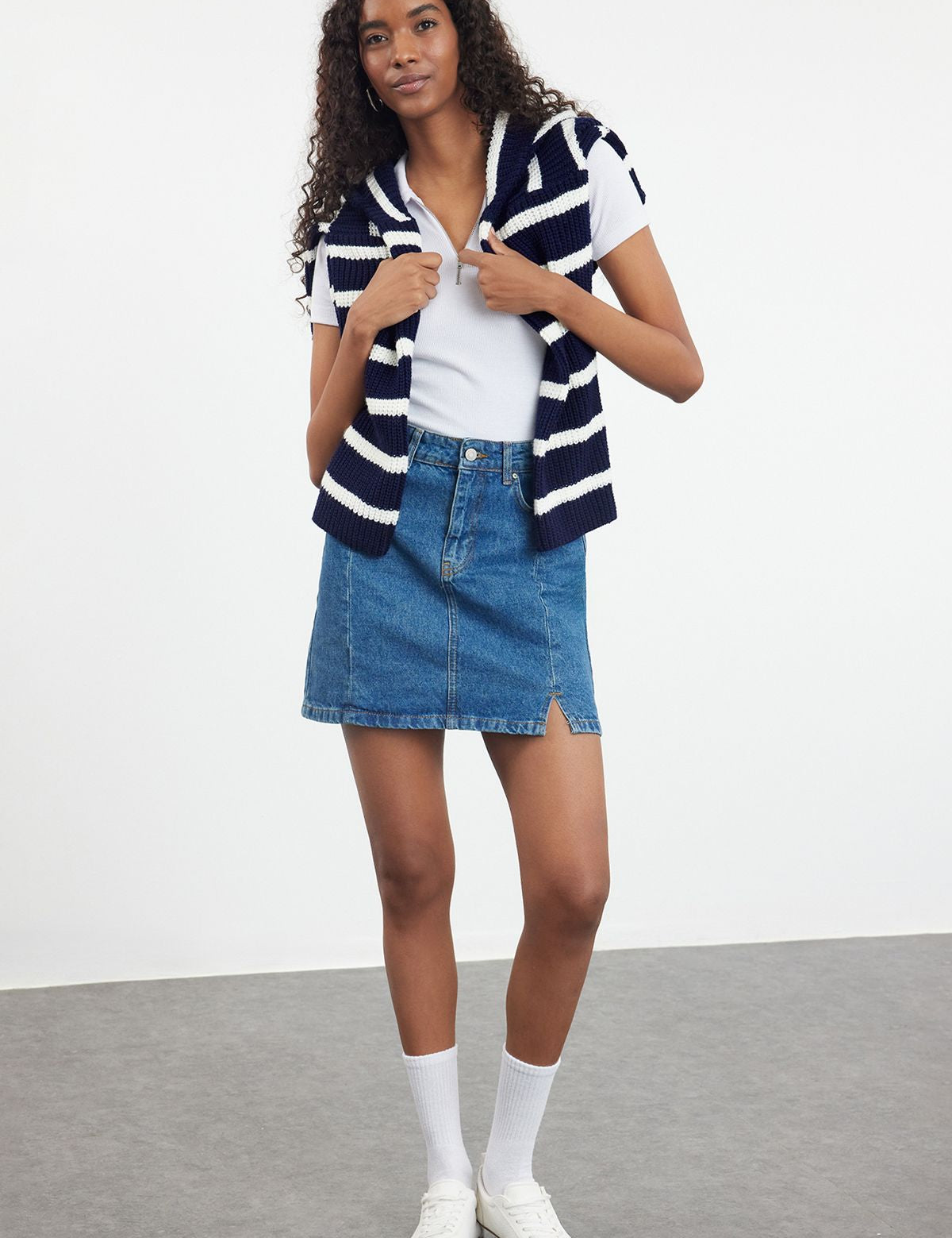 Upgrade your casual wardrobe with this classic denim mini skirt featuring a chic front slit. Perfect for any season, this versatile piece pairs effortlessly with any top. Available now!