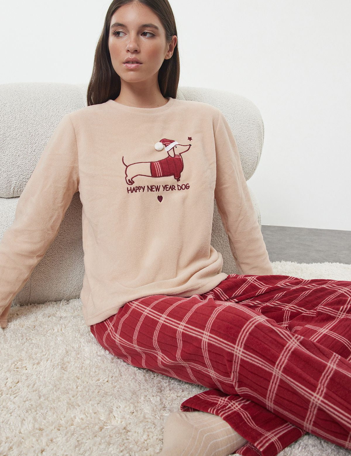 Celebrate the New Year in comfort with our festive dog print pajama set. Cozy beige top and red plaid pants, perfect for winter lounging and gifting. Shop now!