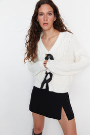  White cable knit cardigan
• Black bow tie sweater
• Cropped knit sweater
• Cozy cable knit cardigan
• Women’s bow detail cardigan
• Elegant white cardigan
• Contrast tie cardigan
• Winter knitwear
• Soft cable knit sweater
• Casual cropped cardigan