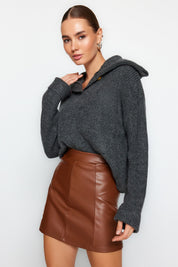 Sleek brown faux leather high-waisted mini skirt with panel detailing. Perfect for casual and formal outfits. Ideal for fall fashion and day-to-night looks.