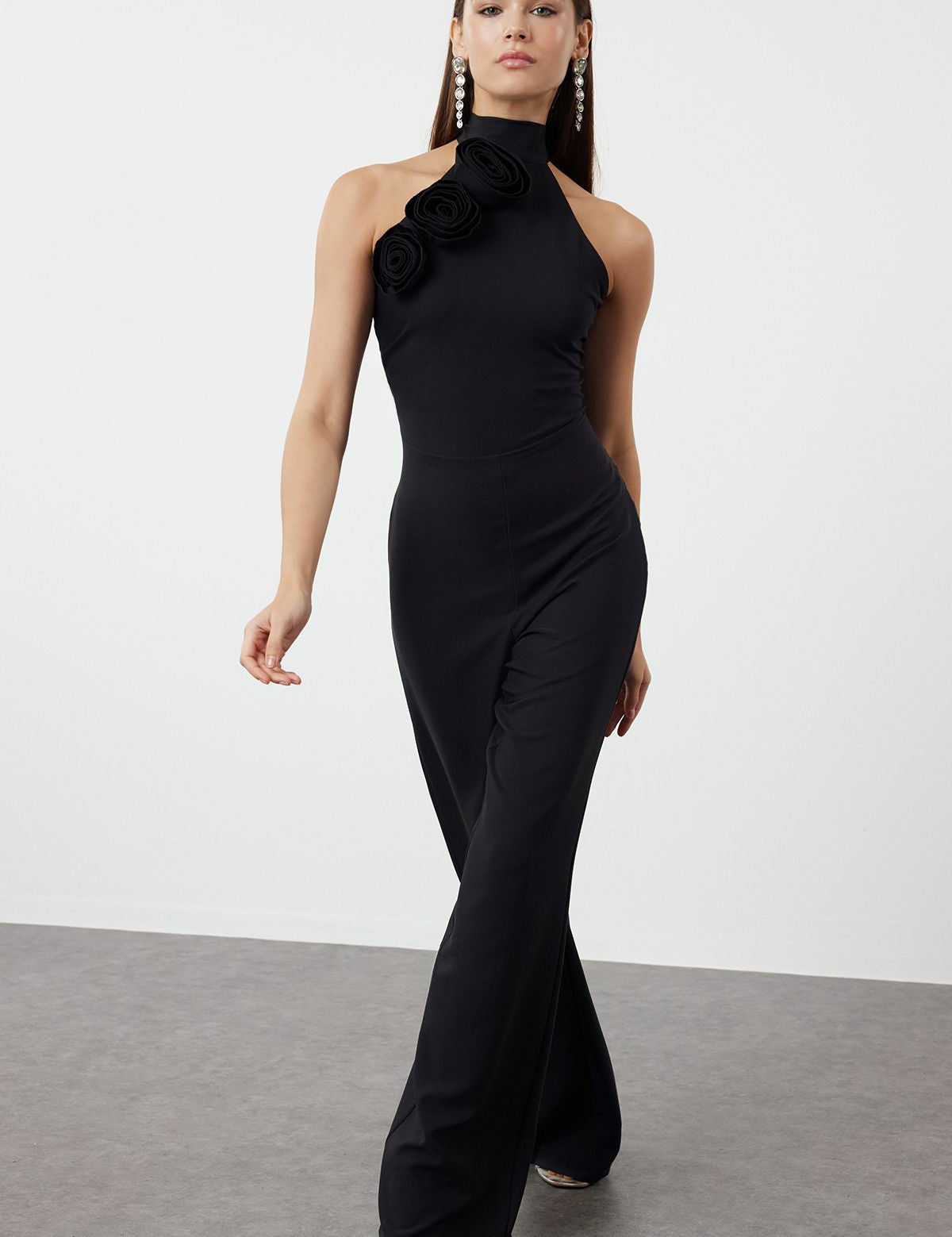 Turn heads with our Elegant Black Halter Jumpsuit featuring a stunning floral detail on the shoulder. Perfect for formal events and evening occasions, this chic and sophisticated jumpsuit offers a flattering fit and timeless style. Shop now for the perfect evening wear!