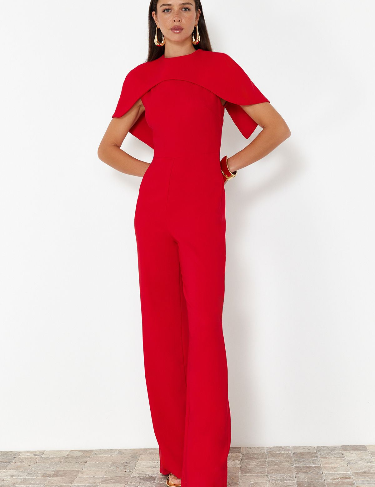 Red cape jumpsuit for women
	•	Elegant one-piece formal jumpsuit
	•	Wide-leg red jumpsuit for events
	•	Tailored red jumpsuit with cape overlay
	•	Evening jumpsuit for weddings and galas
	•	Bold fashion statement outfit for women
	•	Red formal jumpsuit for parties