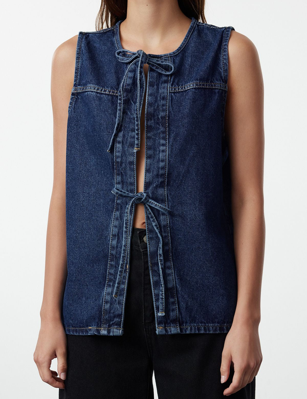 Upgrade your wardrobe with our Classic Denim Vest, the perfect layering piece for any casual outfit. This versatile sleeveless vest features a front tie closure and high-quality denim for a chic and timeless look. Shop now!